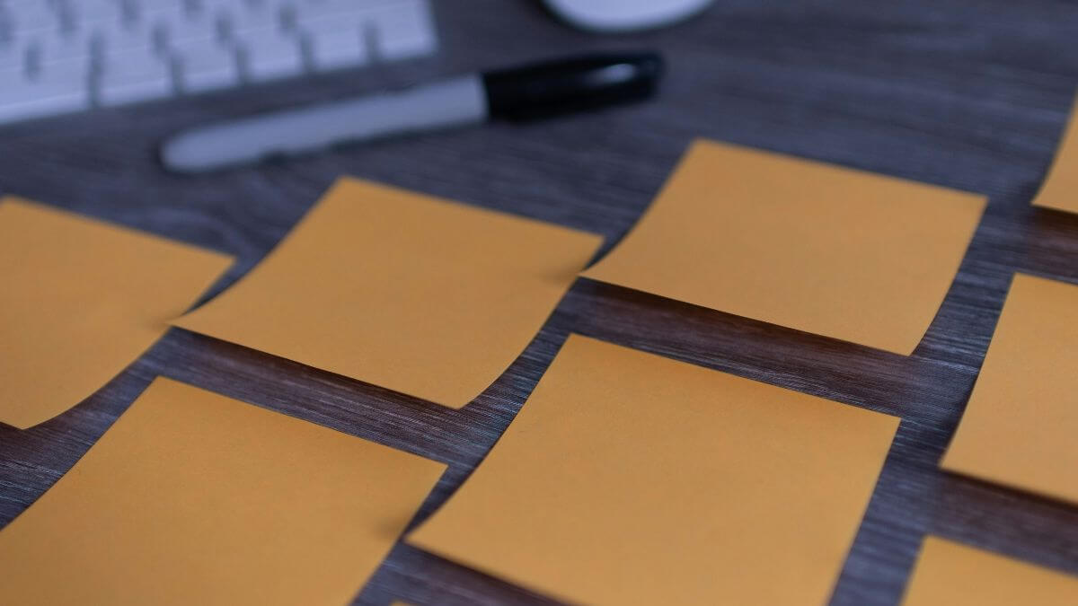 白紙の付箋がたくさん貼ってあるデスクの画像